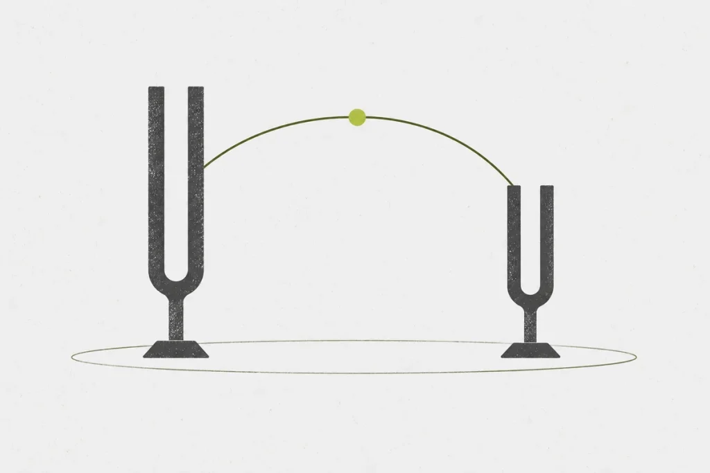 Two tuning forks of different sizes connected by a curved line over an open frame.