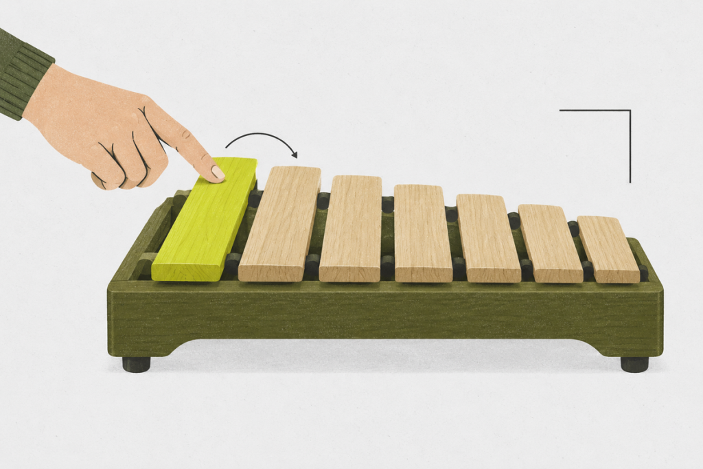 Seven unlabeled wooden tone bars arranged from long to short as a hand begins the sequence.